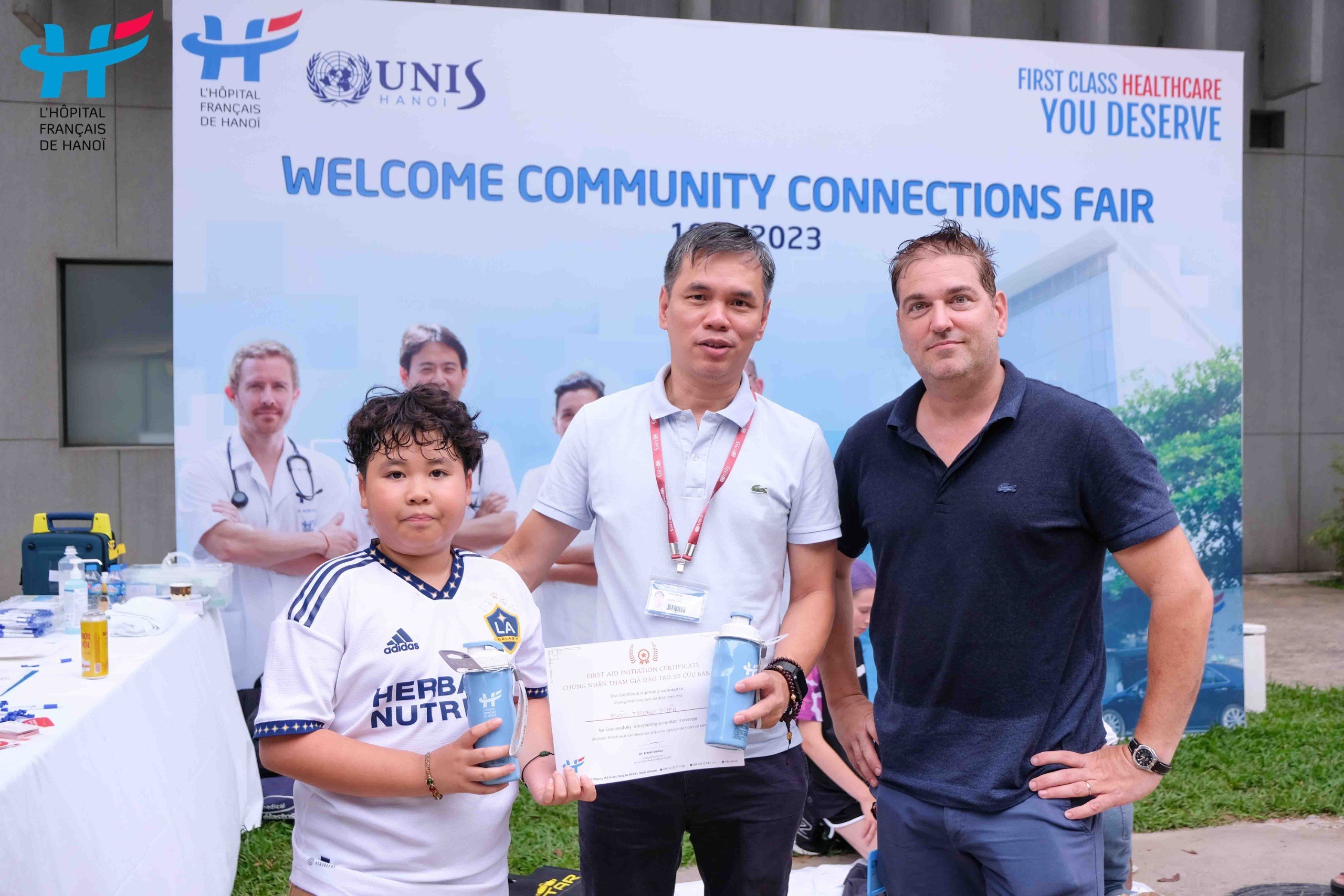 Dr. Erwan Debuc, Chief Medical Officer of HFH, presents certificates and gifts to the families who participated in the First Aid Course at the UNIS Community Connection Fair